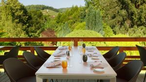 a white table with chairs on a balcony at Hotel-restaurant Les Caudalies in Arbois +33 photos