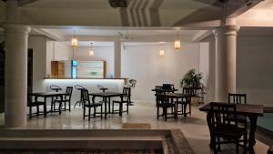 a restaurant with tables and chairs in a room at Chill Hill Hikkaduwa in Hikkaduwa