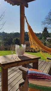 - une table en bois avec 2 verres à vin et un hamac dans l'établissement Loft no campo próximo ao Vale dos Vinhedos, à Garibaldi
