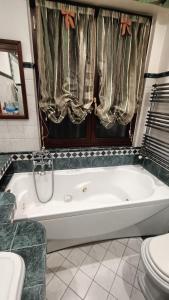 El baño incluye bañera blanca y aseo. en Roma Chic House, en Roma