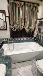 a white bath tub in a bathroom with a toilet at Roma Chic House in Rome