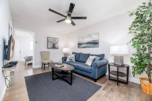 a living room with a blue couch and a ceiling fan at The Guesthouse 2 - Wilton Manors in Fort Lauderdale