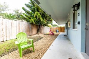 a yard with two green chairs and a fence at The Guesthouse 2 - Wilton Manors in Fort Lauderdale