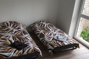 a bed sitting in a room next to a window at LA MAISON POURRIE in Pont-à-Mousson