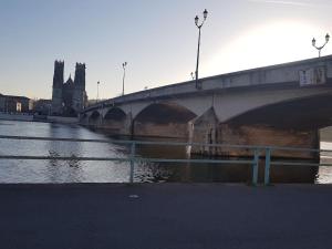 a bridge over a river with a building in the background at LA MAISON POURRIE in Pont-à-Mousson
