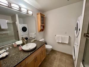 a bathroom with a sink and a toilet and a mirror at Marina View On The Harbour in Ucluelet +9 photos