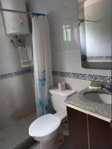 a bathroom with a toilet and a sink and a mirror at Paso del.Sol in Piriápolis