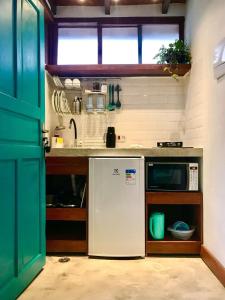 a kitchen with a sink and a dishwasher at Chalés Água Grande in Maresias