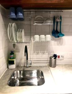 a kitchen counter with a sink and plates and utensils at Chalés Água Grande in Maresias