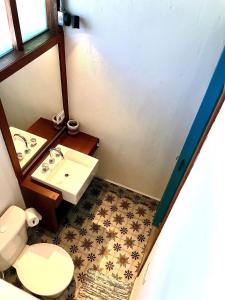 a small bathroom with a toilet and a sink at Chalés Água Grande in Maresias