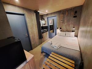 ポボア・デ・バルジンにあるSardines and Friends Hostel 06の小さなベッドルーム(ベッド1台、テレビ付)