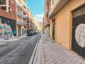 Una calle vacía de la ciudad con grafitis en los edificios en Apartamentos La Brava by gaiarooms, en Salamanca