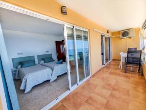 een slaapkamer met een bed en glazen schuifdeuren bij Spectacular Sea Views Benalmádena in Benalmádena