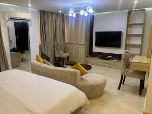 a hotel room with a bed and a flat screen tv at YP George in Lekki