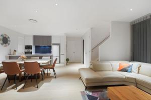 uma sala de estar com um sofá e uma mesa em Nexus Townhouse with Parking and Wi-Fi em Auckland