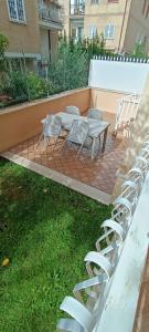 a patio with white chairs and a table and chairs at Roma Chic House in Rome