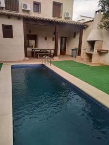 a swimming pool in front of a house at Casa Rural Gafas in El Toboso