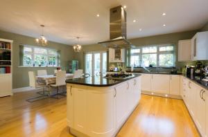 a kitchen with white cabinets and a large island at Leafy Suburban Bed and Breakfast in Northwood