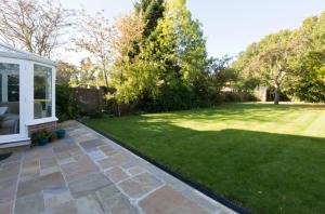 a garden with a lawn and a house at Leafy Suburban Bed and Breakfast in Northwood