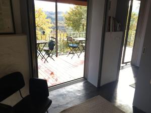 una puerta que conduce a un patio con mesa y sillas en Casa da Eira - Sobrenatura Ecoturismo, en Arcos de Valdevez