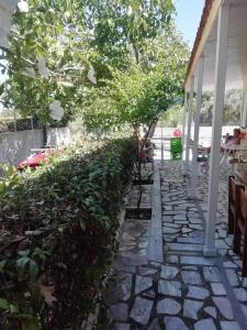 a stone walkway next to a house with trees at Το σπίτι της Δήμητρας in Platamonas