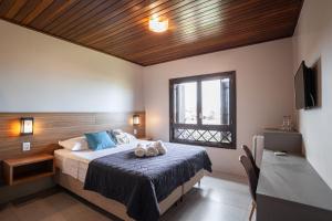um quarto com uma cama grande e uma janela em Parador Casa da Praia em Torres