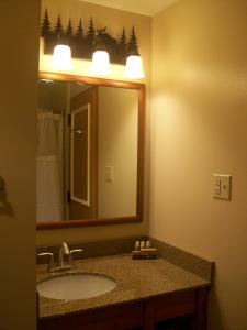 een badkamer met een wastafel en een grote spiegel bij Overlook Lodge and Stone Cottages at Bear Mountain in Highland Falls