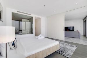 1 dormitorio blanco con 1 cama grande y espejo en D1, Al Jadaf Modern One Bedroom Apartment en Dubái