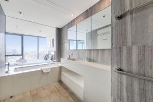 a bathroom with a sink and a large mirror at D1, Al Jadaf Modern One Bedroom Apartment in Dubai