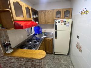 a small kitchen with a stove and a refrigerator at Apartamento con Vista y acceso al lago en Guatape in Guatapé