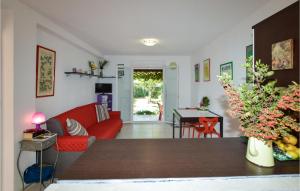セルヴィオーヌにあるBeautiful Home In Cervione With 1 Bedrooms, Outdoor Swimming Pool And Wifiのリビングルーム(赤いソファ、テーブル付)