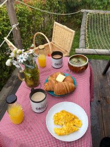 Origen Glamping en Villa de Leyva في فيلا دي ليفا: طاولة مع طعام الإفطار على بطانية نزهة