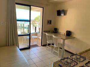 Habitación con cocina con encimera y mesa. en Férias a beira mar - Brilhos do sol, en Bombinhas