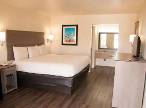 ein Hotelzimmer mit Bett und Fernseher in der Unterkunft Exacta Inn in Minden