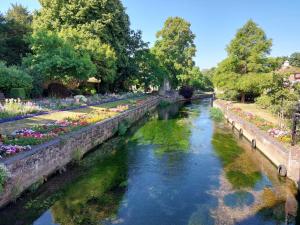 a canal in a park with flowers and trees at 1 Bed - Sleeps 2 - Free Parking - Wi-Fi in Herne Bay