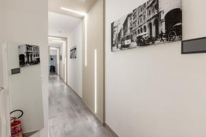 a hallway with black and white pictures on the walls at DELEDDA HOME in Cagliari