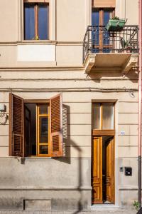 a building with wooden doors and a balcony at DELEDDA HOME in Cagliari