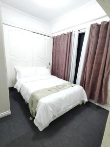 a bedroom with two beds and a window at Comfort room in Manila