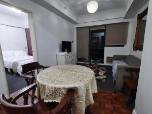 a living room with a table and a bed at Comfort room in Manila