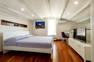 a bedroom with a bed and a flat screen tv at Casa Melina in Scicli