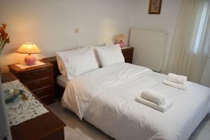 a bedroom with a white bed with towels on it at Thalia's House in Tríkala