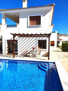 a villa with a swimming pool in front of a house at Espectacular Villa PISCINA PRIVADA Altaona GOLF in Murcia