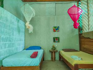 two twin beds in a room with two lanterns at ROSA'S HOUSE in Puerto Maldonado
