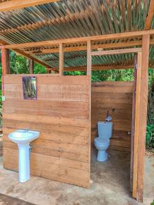 baño de madera con aseo y lavamanos en ROSA'S HOUSE en Puerto Maldonado