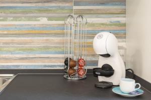 a kitchen counter with a coffee maker and cups at DELEDDA HOME in Cagliari