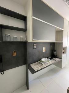 uma cozinha com paredes e prateleiras em preto e branco em Apartamento Confortável e Completo - JTR em Maceió