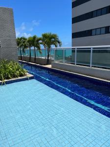 uma piscina ao lado de um edifício em Apartamento Confortável e Completo - JTR em Maceió