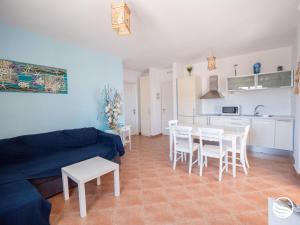 a living room with a blue couch and a table and chairs at Sogno Greco in Elafonisos