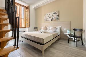 una camera con letto, scrivania e scala di DELEDDA HOME a Cagliari