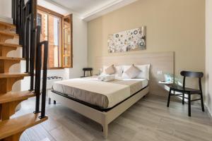 a bedroom with a bed and a desk and a staircase at DELEDDA HOME in Cagliari